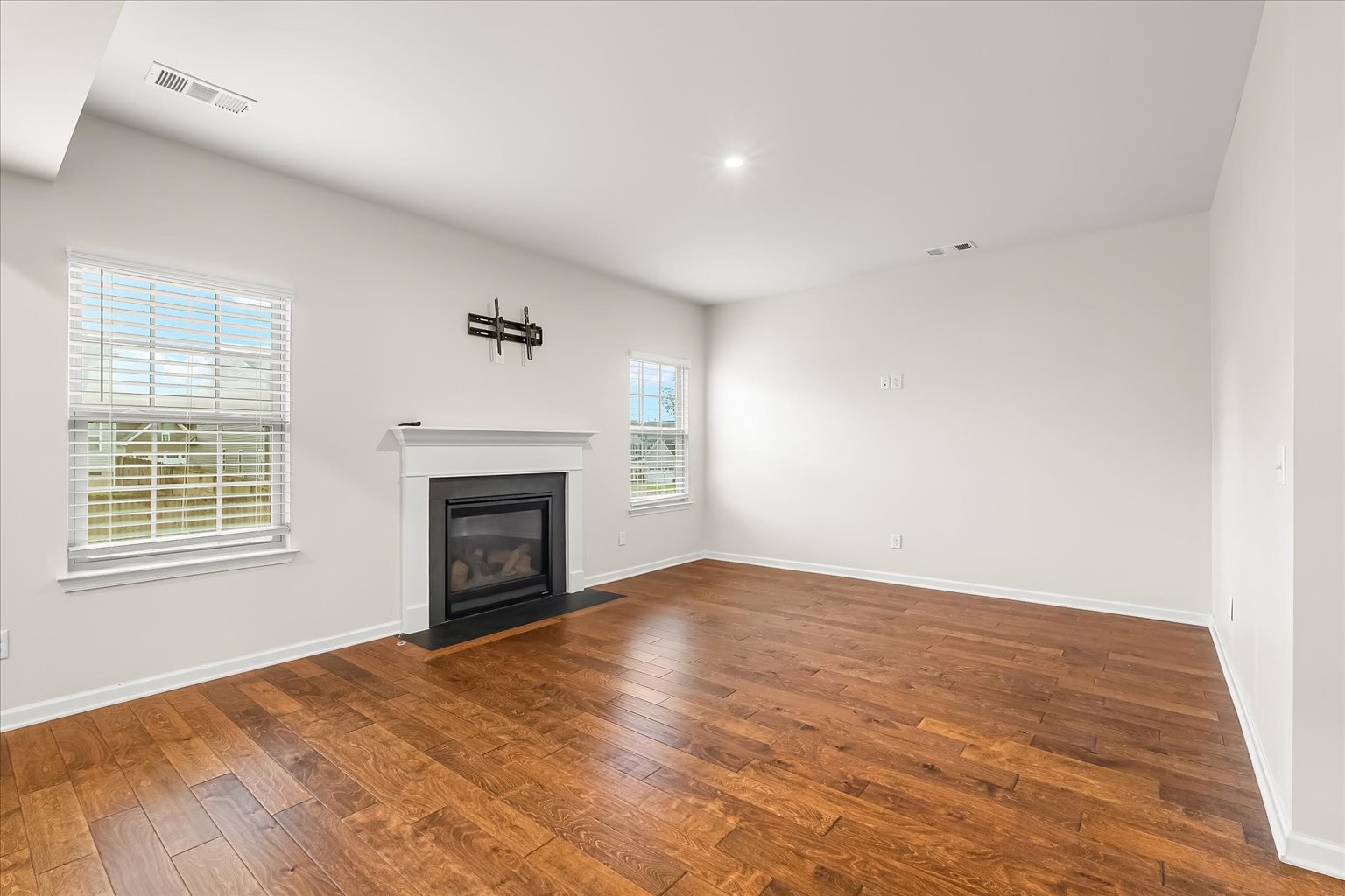 3204 Garrett Lane Columbia, TN 38401 - Photo 15 of 33 an empty room with windows a fireplace and wooden floor