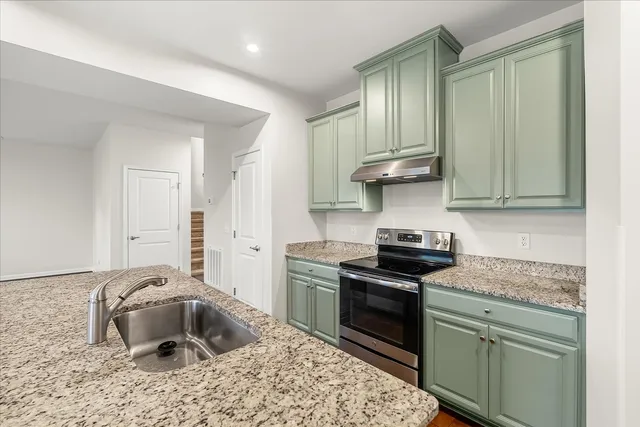 a kitchen with stainless steel appliances granite countertop a sink stove and cabinets