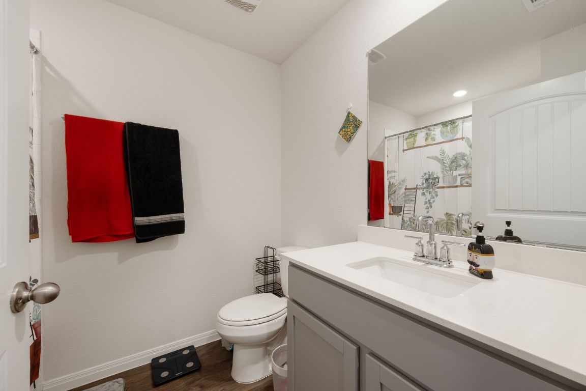 13908 Mamie Eisenhower Road Manor, TX 78653 - Photo 17 of 23 a bathroom with a toilet sink and mirror