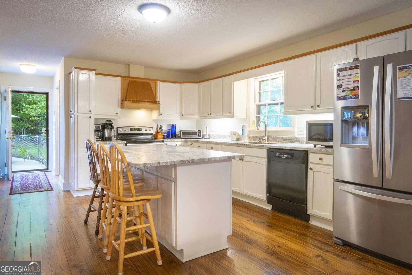 144 Fussen Strasse Helen, GA 30545 - Photo 15 of 38 a kitchen with stainless steel appliances granite countertop a stove a sink a refrigerator and island with wooden floor