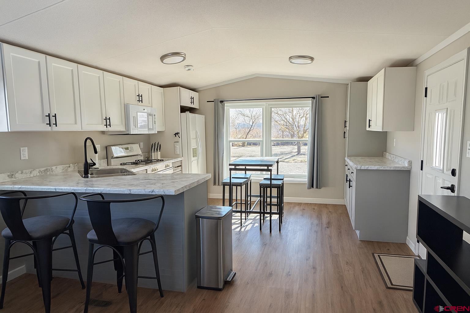 676 Highway 50, Unit SPACE 44 Delta, CO 81416 - Photo 11 of 29 a kitchen with granite countertop a sink cabinets and wooden floor