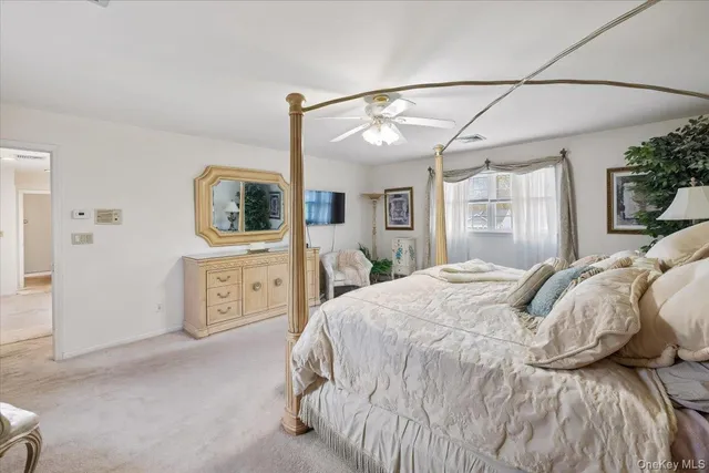 a bedroom with a bed a flat screen tv and chandelier