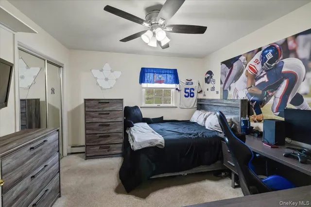 a bedroom with a bed and a flat tv screen on the dresser