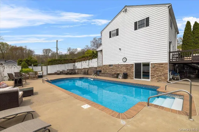 a view of a house with swimming pool and sitting area