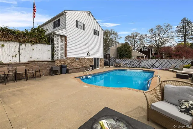 a swimming pool with outdoor seating and yard