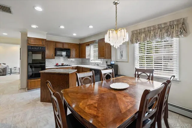 a kitchen with stainless steel appliances granite countertop a stove a kitchen island a refrigerator a stove a dining table and chairs