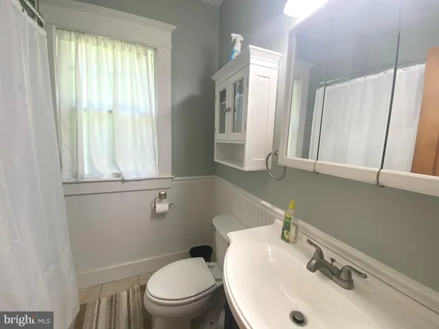a bathroom with a sink toilet and mirror