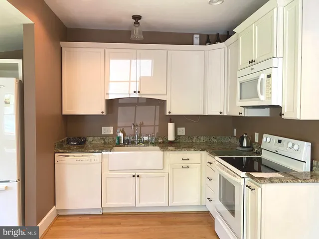 a kitchen with a sink a stove and cabinets