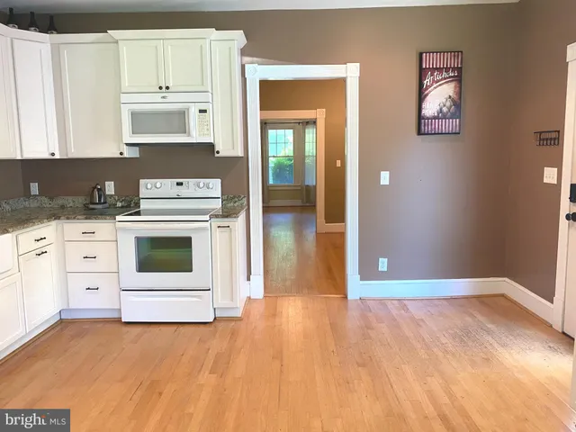 a kitchen with a stove cabinets and wooden floor
