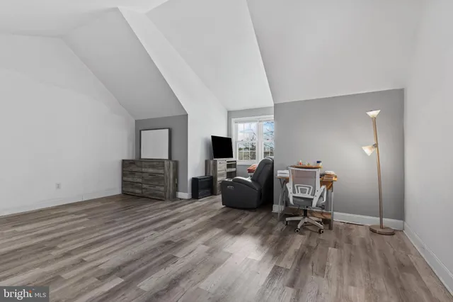 a view of a hallway with wooden floor and a chandelier