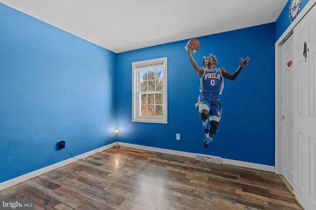 a bedroom with a bed a flat screen tv and dresser
