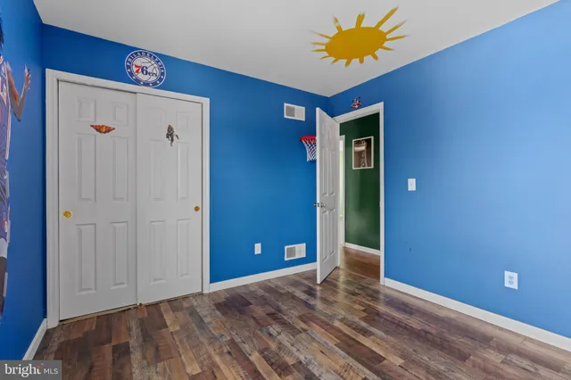 a view of a room with wooden floor and a flat screen tv