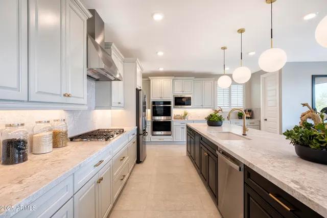 a large kitchen with stainless steel appliances granite countertop a lot of counter space and wooden floor