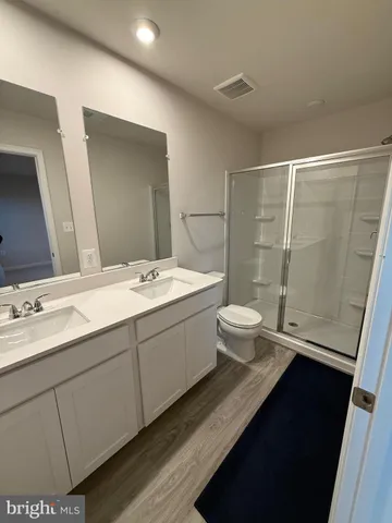 a bathroom with a double vanity sink toilet and shower