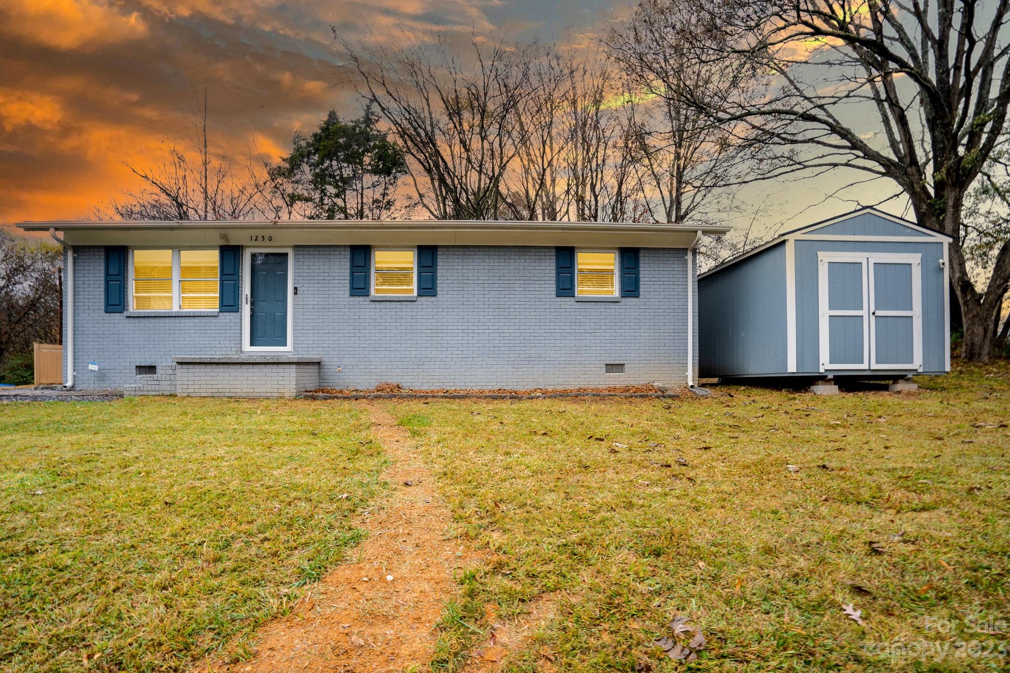 a front view of a house with yard and trees