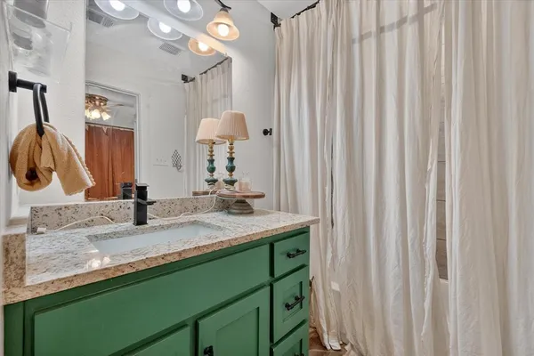 a bathroom with a granite countertop sink and a mirror