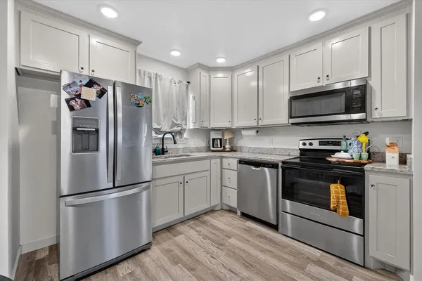 a kitchen with stainless steel appliances granite countertop a refrigerator stove a sink and a microwave