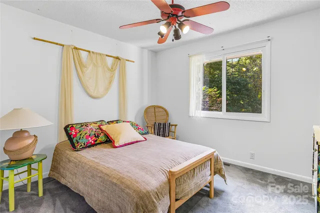 a bedroom with a bed and a chandelier fan