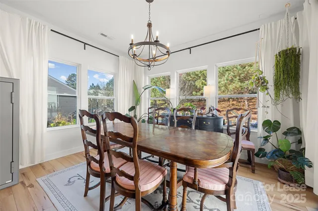a dining room with furniture a chandelier and wooden floor