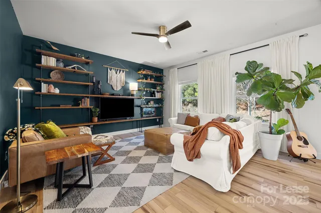 a bedroom with a bed a couch and a potted plant