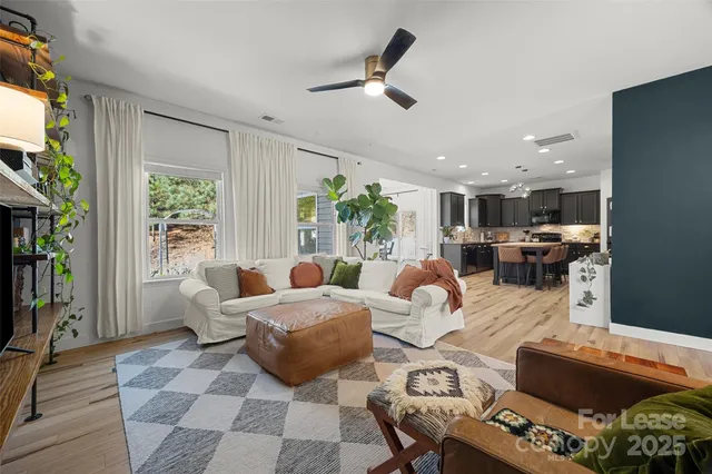 a living room with furniture fireplace and a large window