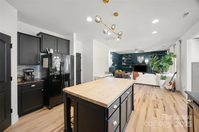a kitchen with kitchen island a counter top space a sink appliances and cabinets