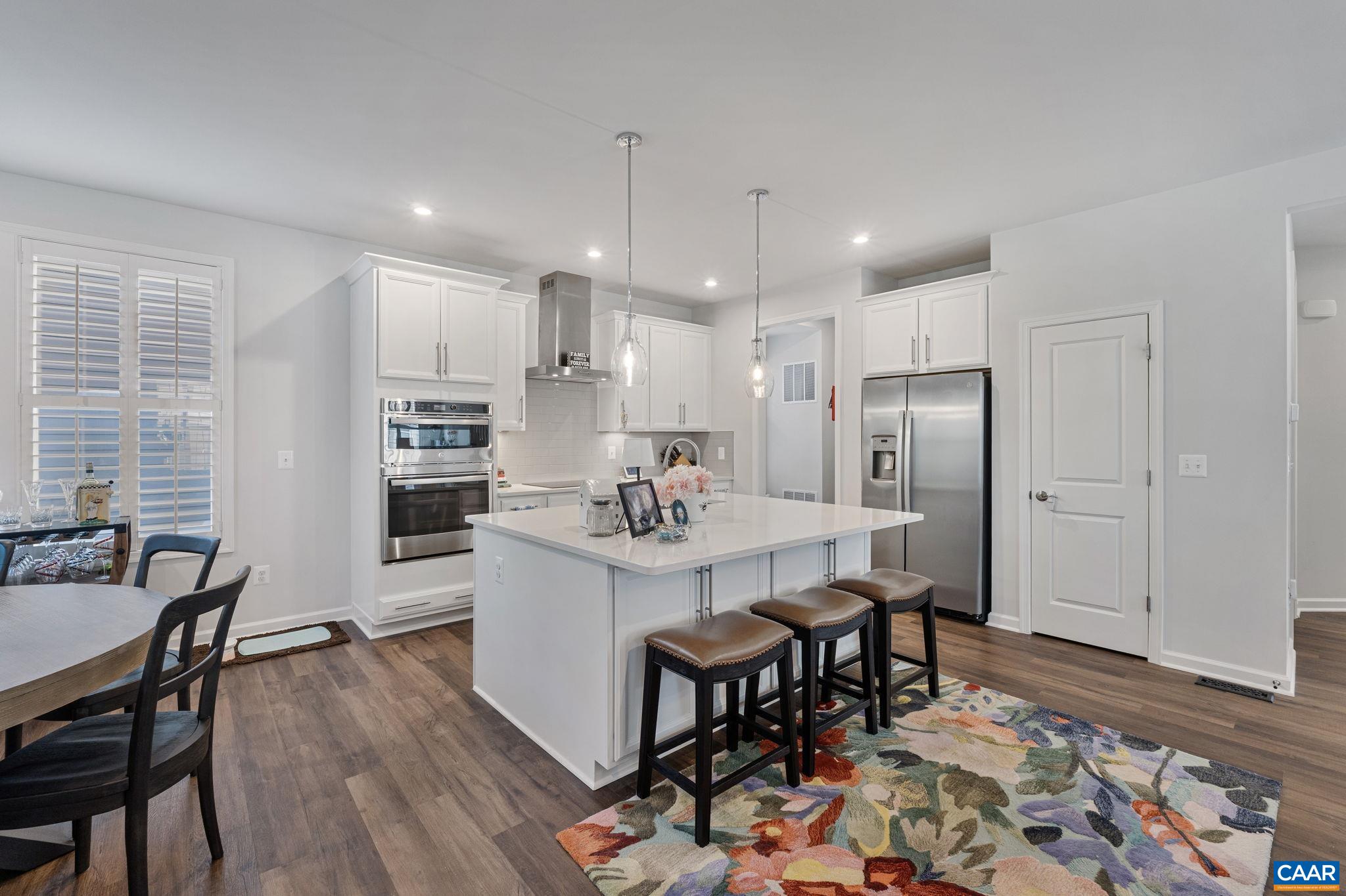 2879 Rambling Brook Lane Crozet, VA 22932 - Photo 14 of 63 a kitchen with stainless steel appliances a dining table chairs and wooden floor