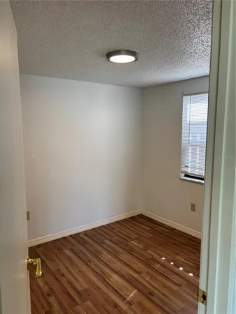 a view of a room with wooden floor and white walls