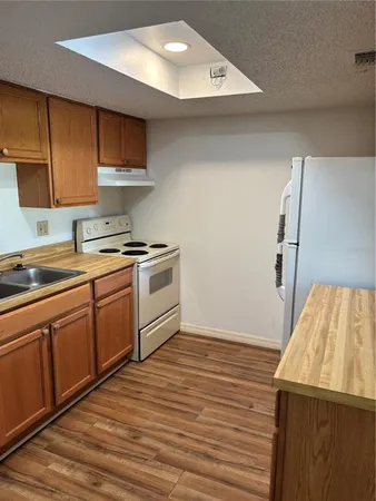 a kitchen with a sink a stove and cabinets