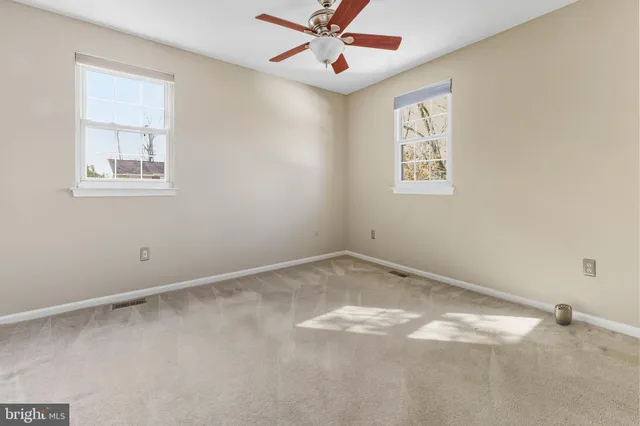 an empty room with a window and ceiling fan