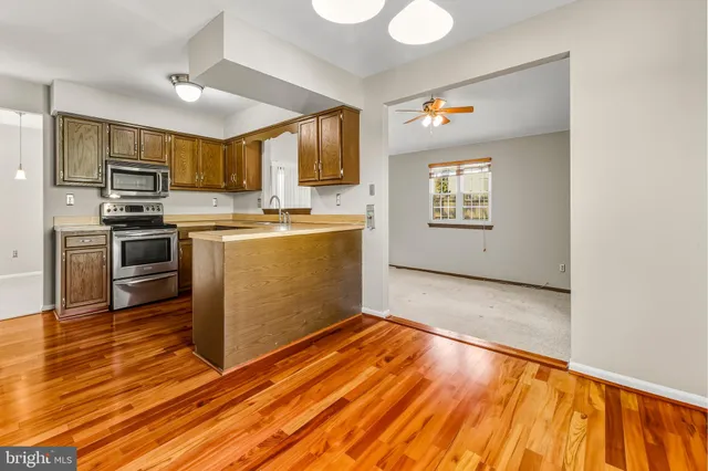 a kitchen with stainless steel appliances a stove top oven a sink dishwasher and a refrigerator