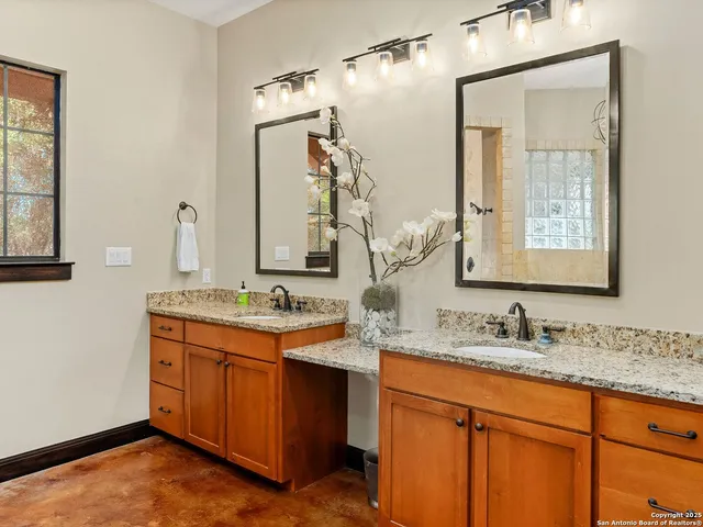 a bathroom with a granite countertop sink double and mirror