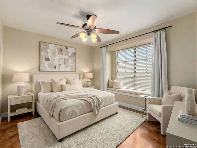 a bedroom with a large bed couch and a window