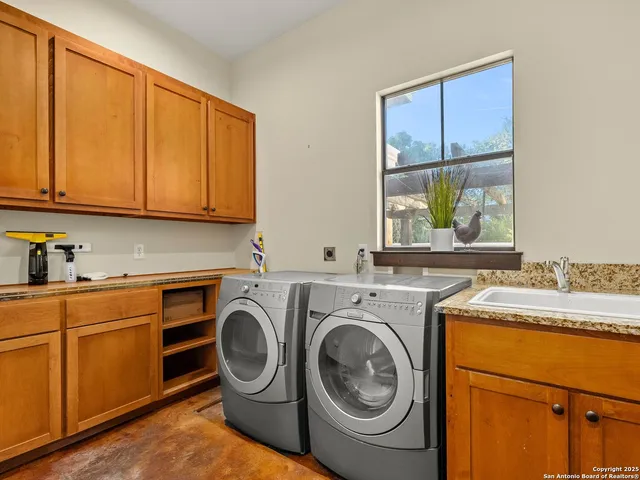 a utility room with sink dryer and washer