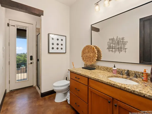 a bathroom with a granite countertop sink mirror vanity and toilet