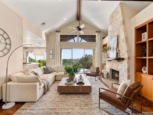 a living room with furniture fireplace and a large window