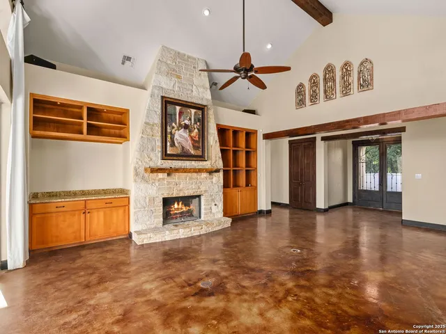 a view of an empty room with window fireplace and a kitchen