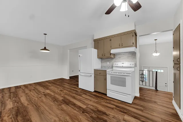 a kitchen with a stove cabinets and wooden floor