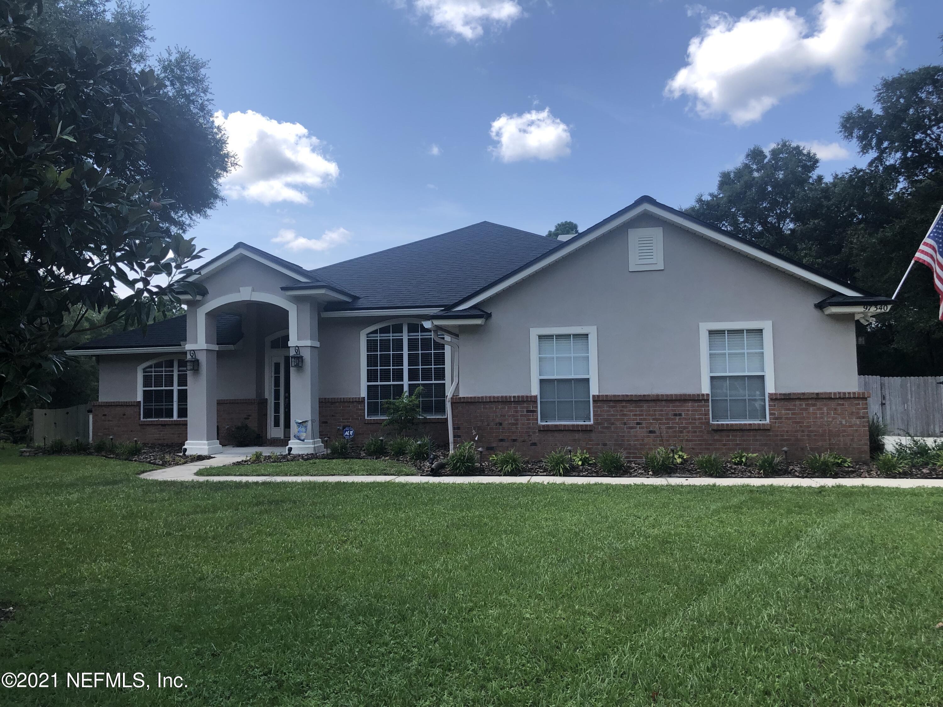 97340 Castle Ridge Drive Yulee, FL 32097 - Photo 1 of 1 a front view of a house with a garden and yard