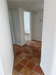 an empty room with wooden floor fireplace and windows