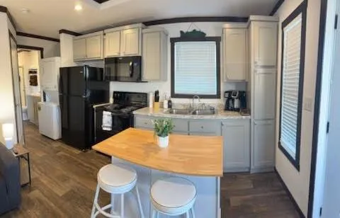 a kitchen with stainless steel appliances a dining table chairs refrigerator and sink