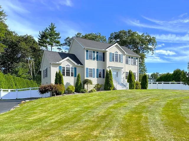 a front view of a house with a garden and trees