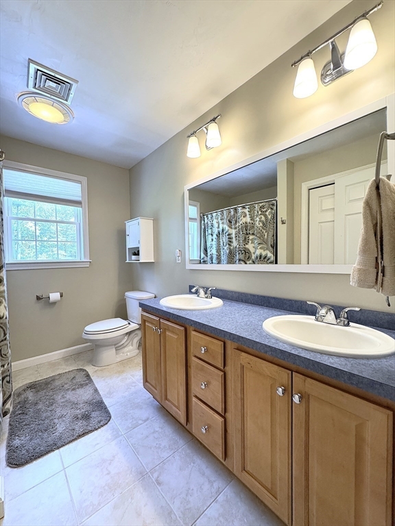 9 Noble Street Dudley, MA 01571 - Photo 27 of 41 a spacious bathroom with a double vanity sink a toilet and a mirror