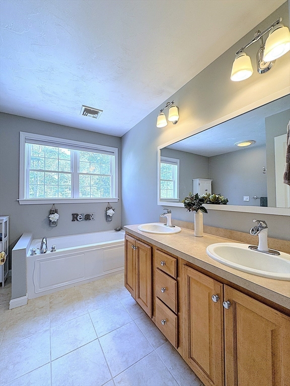 9 Noble Street Dudley, MA 01571 - Photo 30 of 41 a bathroom with a granite countertop sink mirror bathtub and next to a window