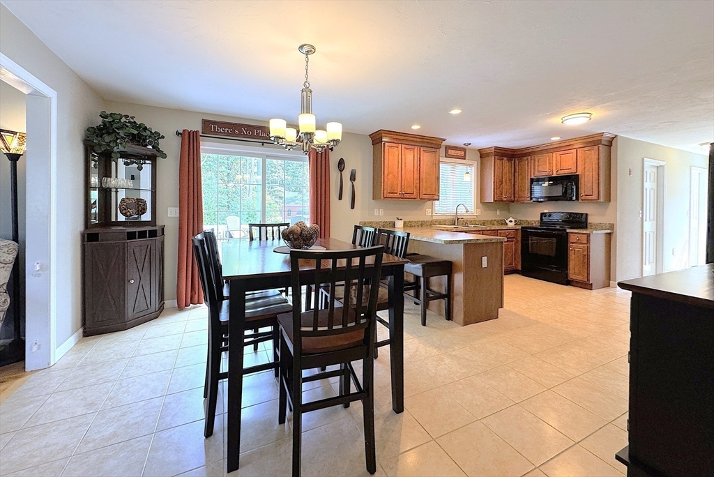 9 Noble Street Dudley, MA 01571 - Photo 9 of 41 a kitchen with stainless steel appliances kitchen island granite countertop a table chairs sink and cabinets