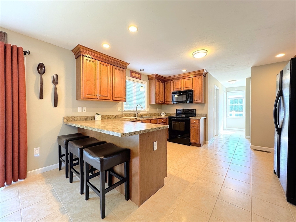 9 Noble Street Dudley, MA 01571 - Photo 10 of 41 a kitchen with stainless steel appliances granite countertop a refrigerator and a stove top oven