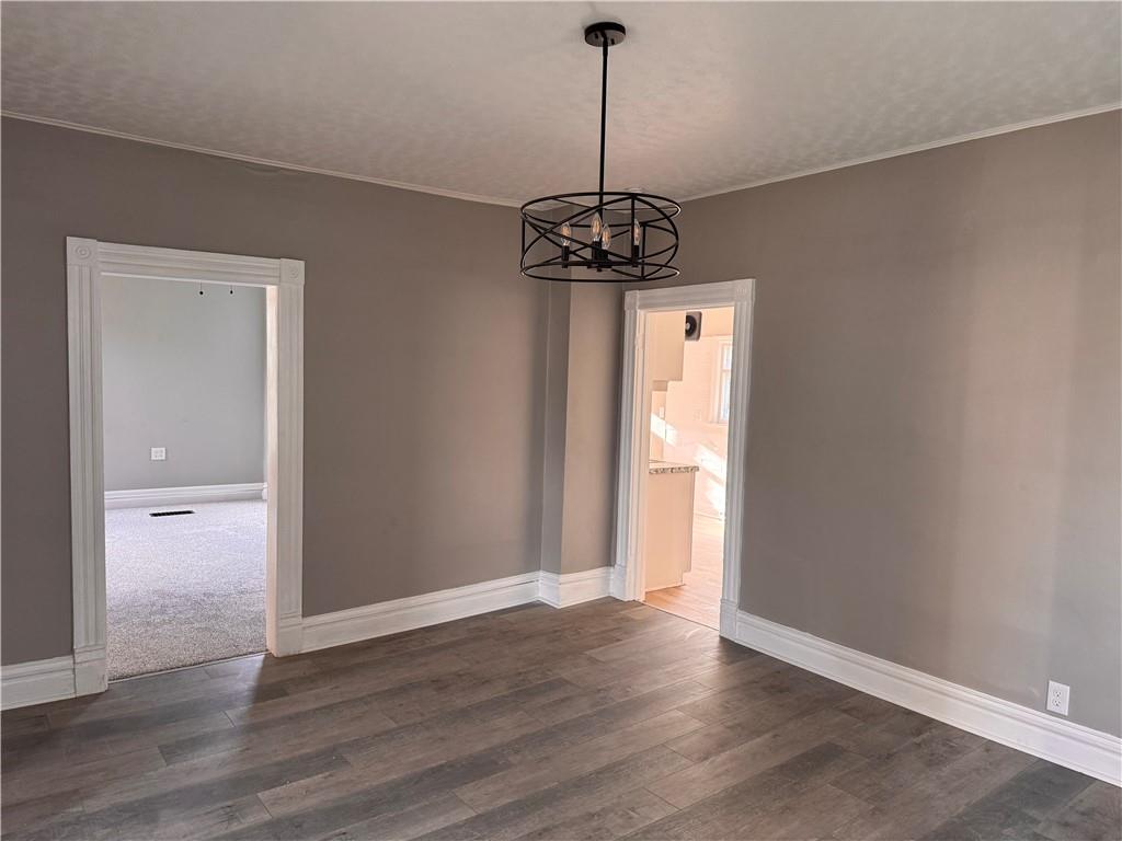 809 Linden Street Sharon, PA 16146 - Photo 3 of 17 a view of a hallway with wooden floor and a chandelier