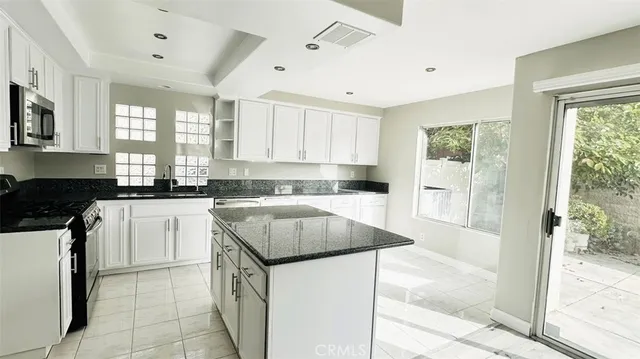 a kitchen with granite countertop white cabinets and white appliances