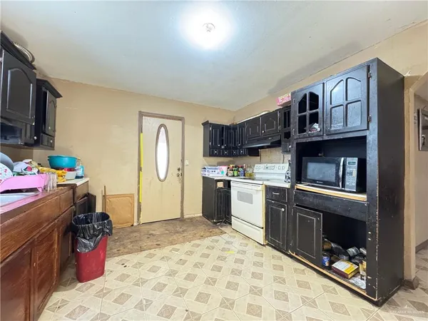 a kitchen with a refrigerator and a stove top oven