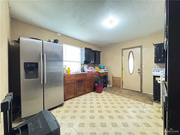 a kitchen with stainless steel appliances kitchen island granite countertop a refrigerator and a sink
